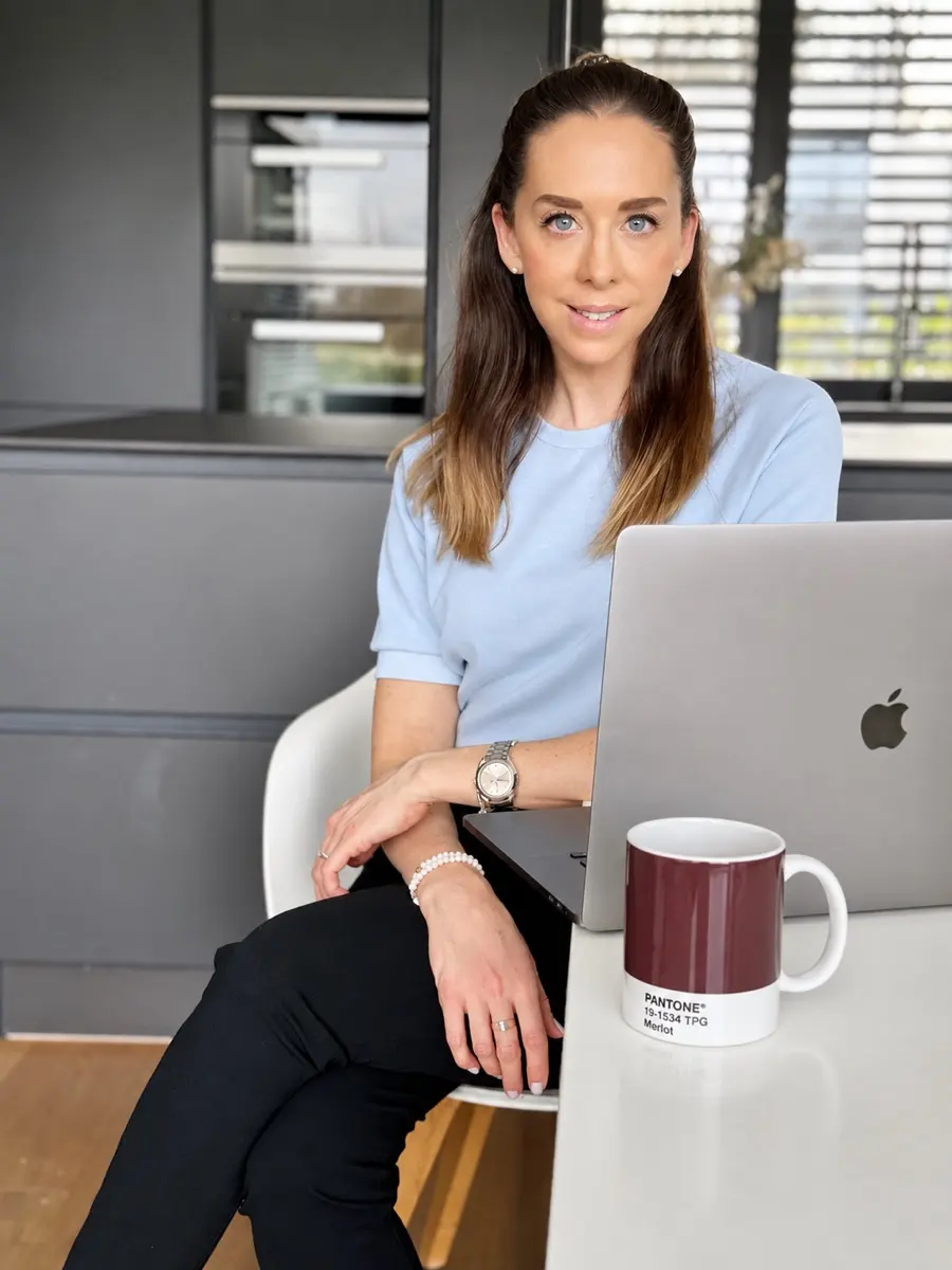 Simona, Gründerin von Room Couture, sitzt an ihrem Arbeitsplatz und blickt in die Kamera.